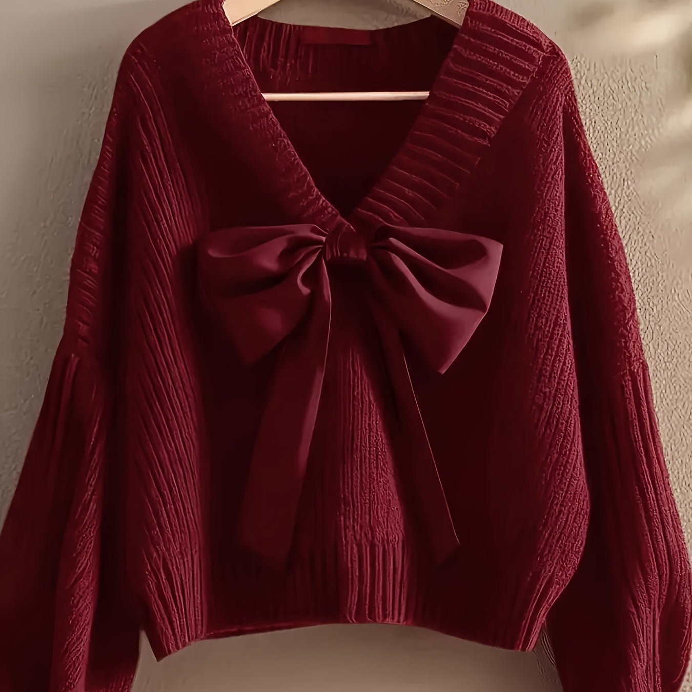Women's ribbed long-sleeve V-neck sweater with a large bow