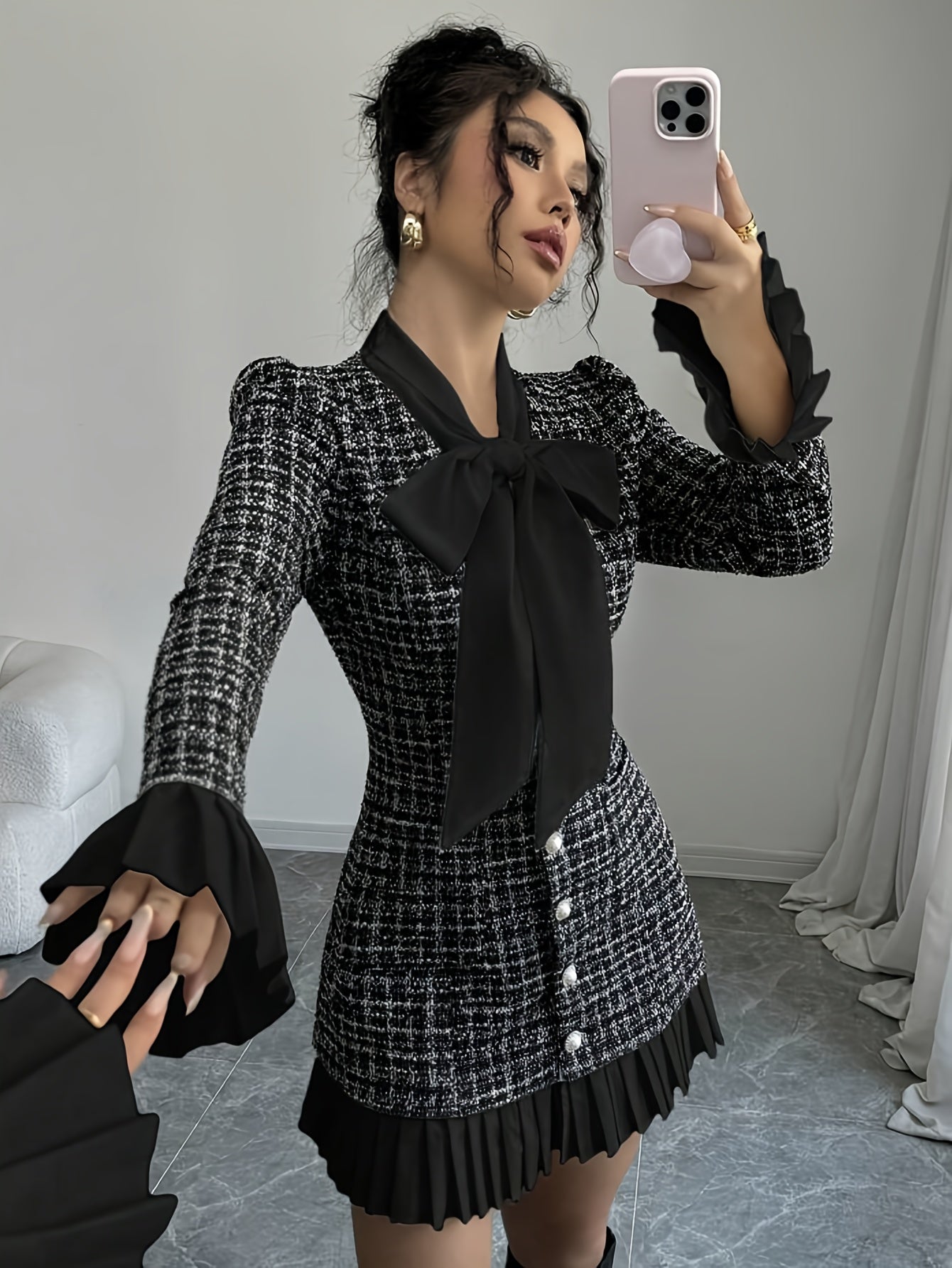 Black-and-white checked dress with a bow and pleated details