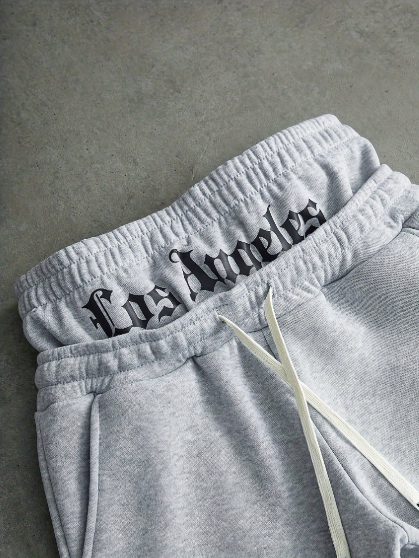 Loose-fit men's joggers with embroidered lettering on the legs, drawstring waistband, black