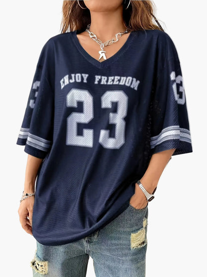 Women's streetwear oversized jersey shirt with number print and wide destroyed jeans – urban casual look