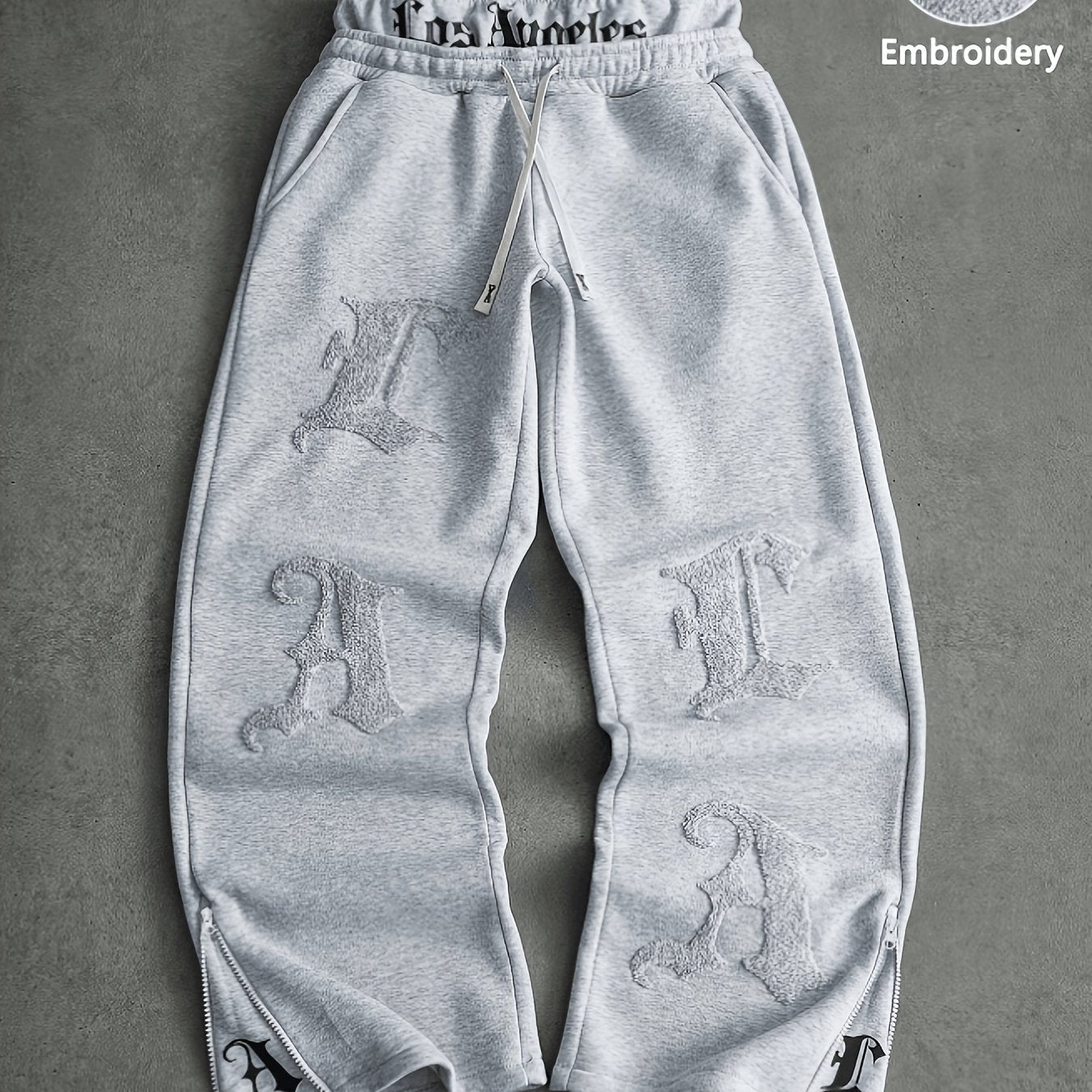 Loose-fit men's joggers with embroidered lettering on the legs, drawstring waistband, black