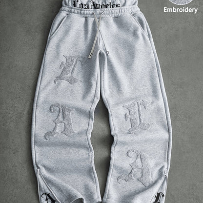 Loose-fit men's joggers with embroidered lettering on the legs, drawstring waistband, black