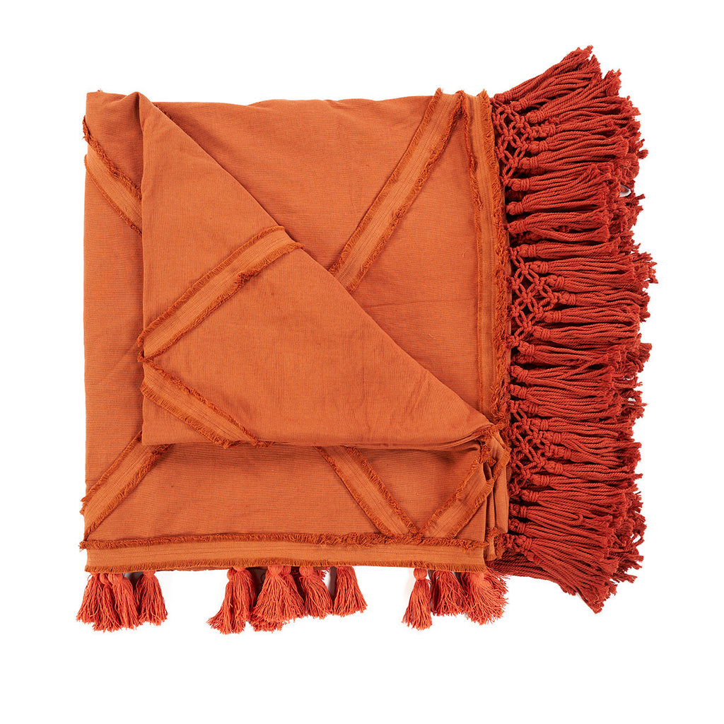 Opgevouwen terracotta plaid van katoen met diagonale banen, lange franjes en kwastjes