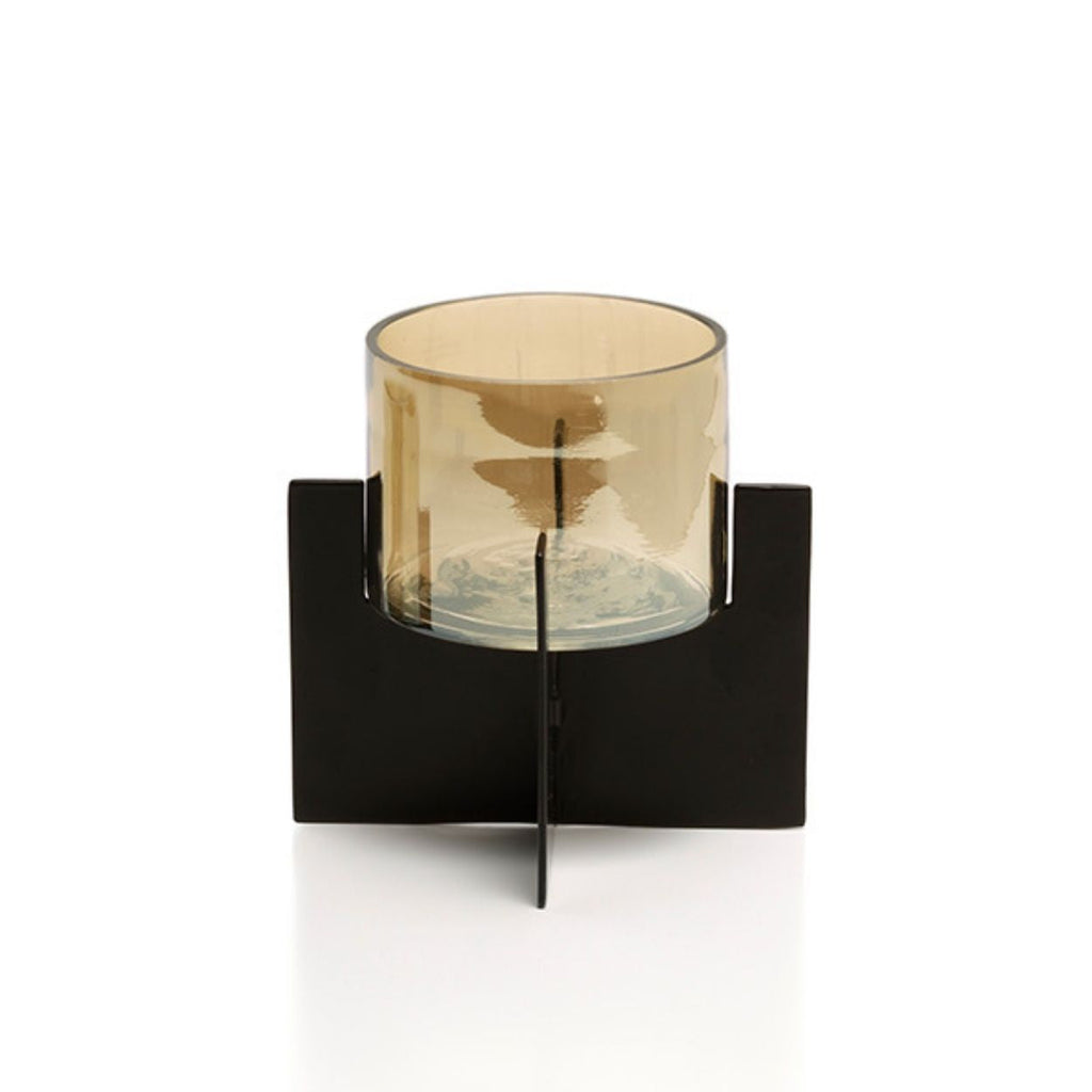 Windlicht met amberkleurige glazen cilinder op een zwart kruisvormig metalen frame