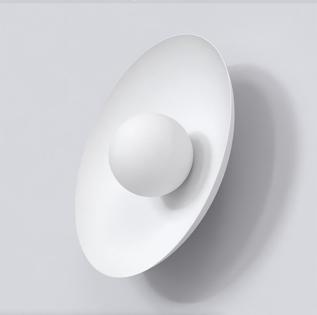 Witte wandlamp met ovale rugplaat en ronde witte bol aan een lichtgrijze wand