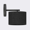 Zwarte wandlamp met ronde wandplaat, slanke arm en zwarte stoffen cilinderkap