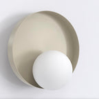Wandlamp met witte bolkap voor een ronde, matte schijf in mokka