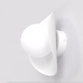 Witte wandlamp met ronde bol en lintvormig scherm aan een lichte wand