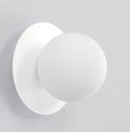 Witte wandlamp met matte ronde bol voor een ronde witte achterplaat tegen een lichte wand