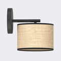 Wandlamp met zwarte wandplaat en arm en een cilindrische rotan kap met zwarte randen