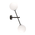 Zwarte wandlamp met twee witte glazen bollen aan een diagonale stalen arm