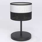 Zwarte tafellamp met ronde kap, grijs stoffen bovendeel en zwart geperforeerd onderdeel, op ronde zwarte voet