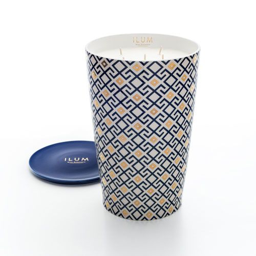 Grote geurkaars in wit vat met blauw-goud Arabesque-patroon, met blauw schaaltje ernaast