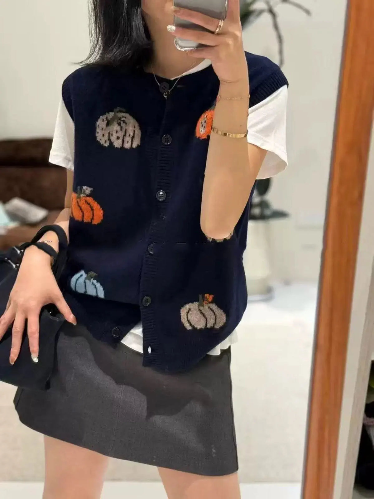 Women's knitted vest with pumpkin motifs, button placket, and round neckline