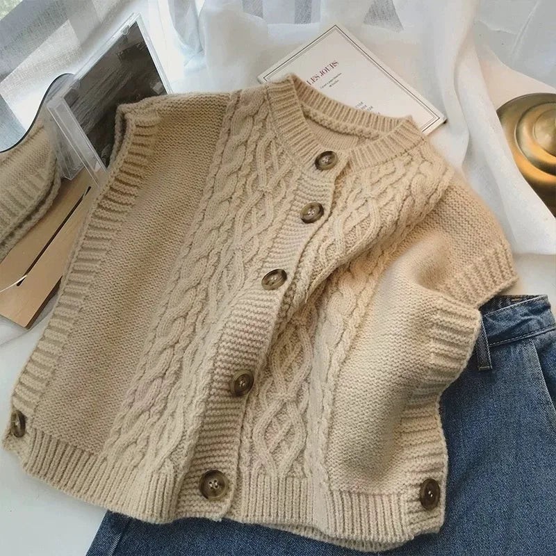 Women's cropped sleeveless cardigan with cable knit pattern, crew neck, and button placket