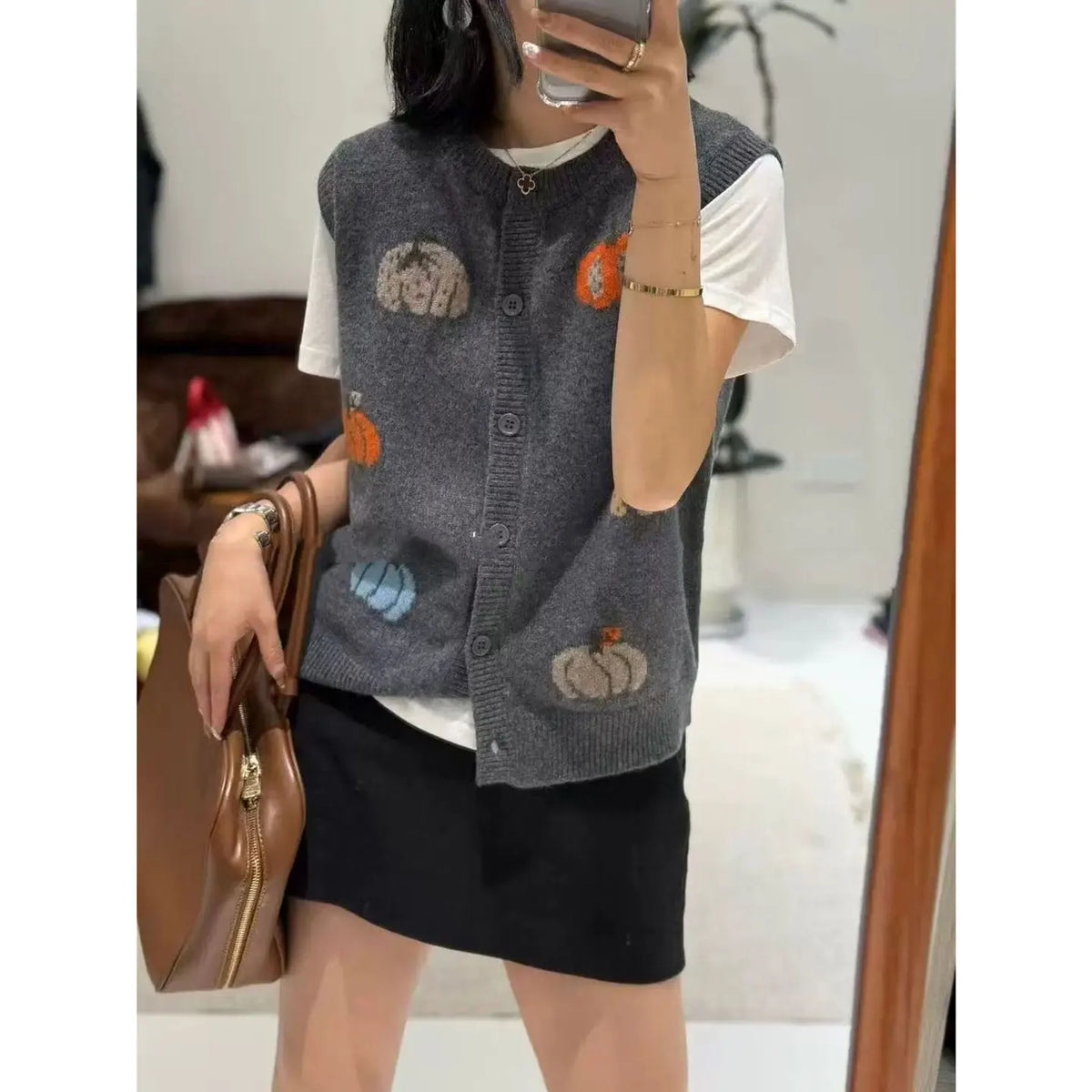 Women's knitted vest with pumpkin motifs, button placket, and round neckline