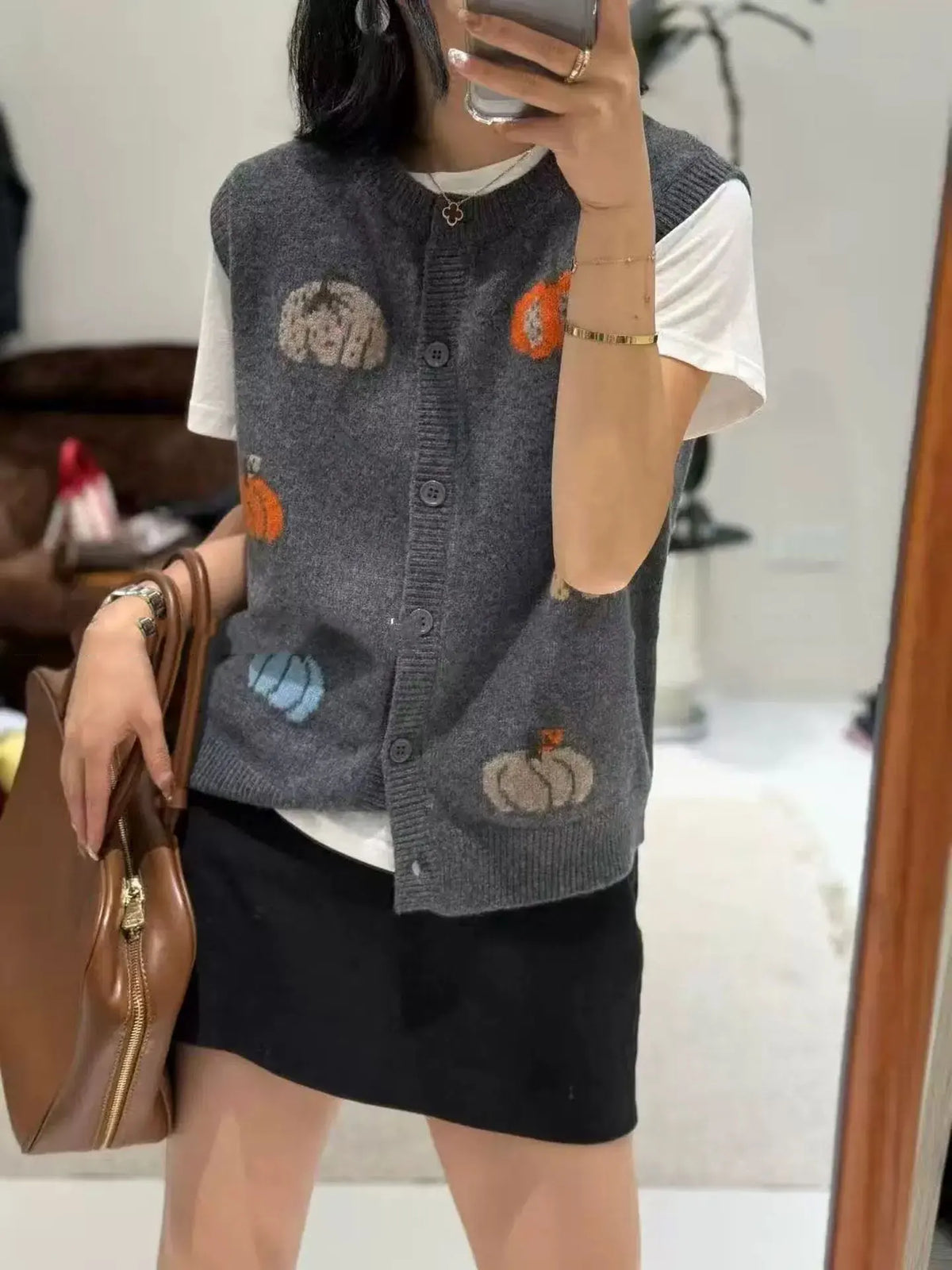 Women's knitted vest with pumpkin motifs, button placket, and round neckline