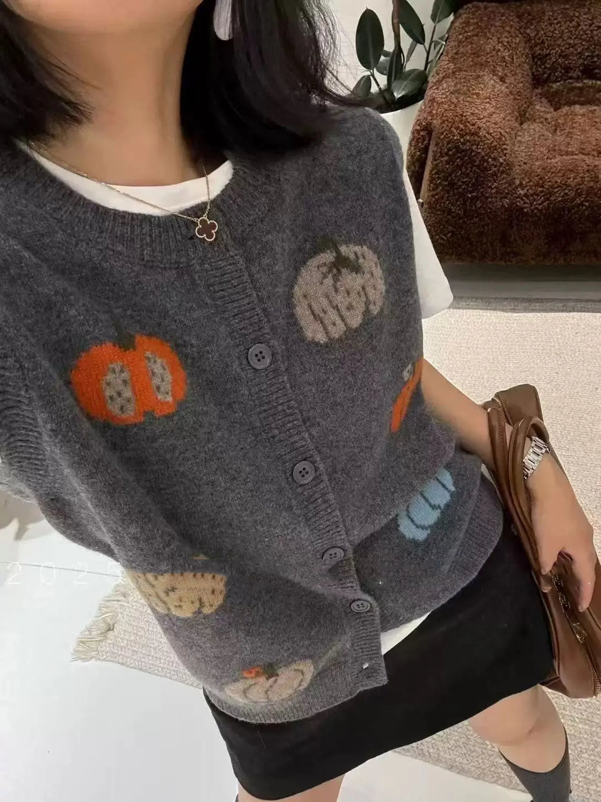 Women's knitted vest with pumpkin motifs, button placket, and round neckline