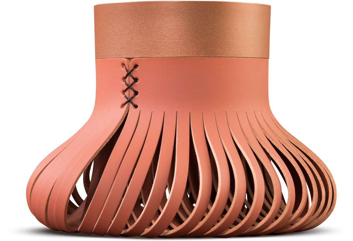Bolvormig object met terracotta repen en een koperkleurige bovenrand met kruissteken, zijaanzicht op witte achtergrond