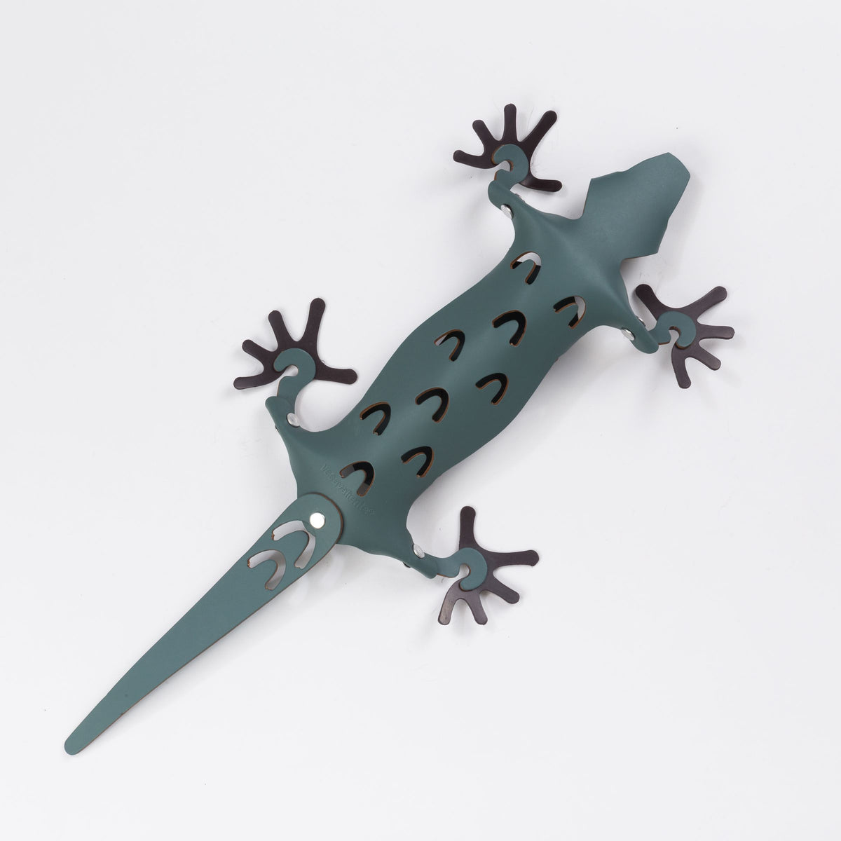 Groene magnetische hagedis-organiser van kunststof met donkerbruine pootjes en uitsparingen op een witte achtergrond