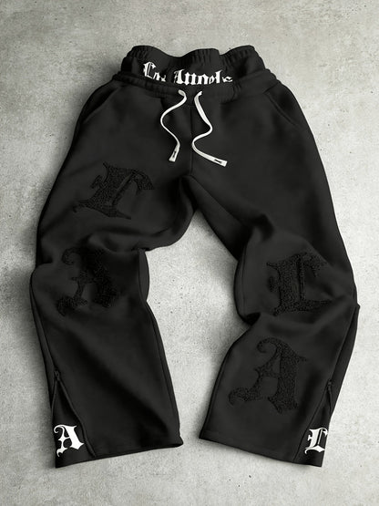 Loose-fit men's joggers with embroidered lettering on the legs, drawstring waistband, black