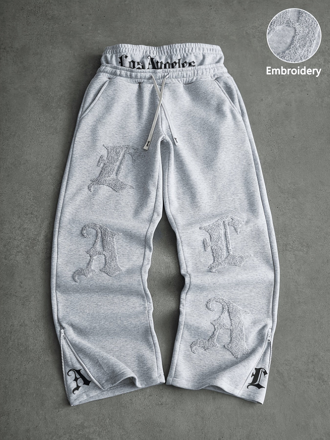 Loose-fit men's joggers with embroidered lettering on the legs, drawstring waistband, black