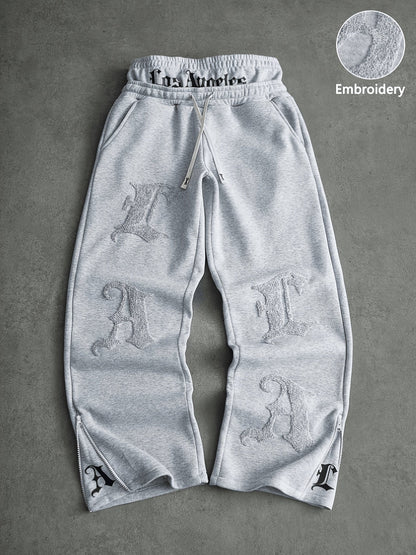 Loose-fit men's joggers with embroidered lettering on the legs, drawstring waistband, black