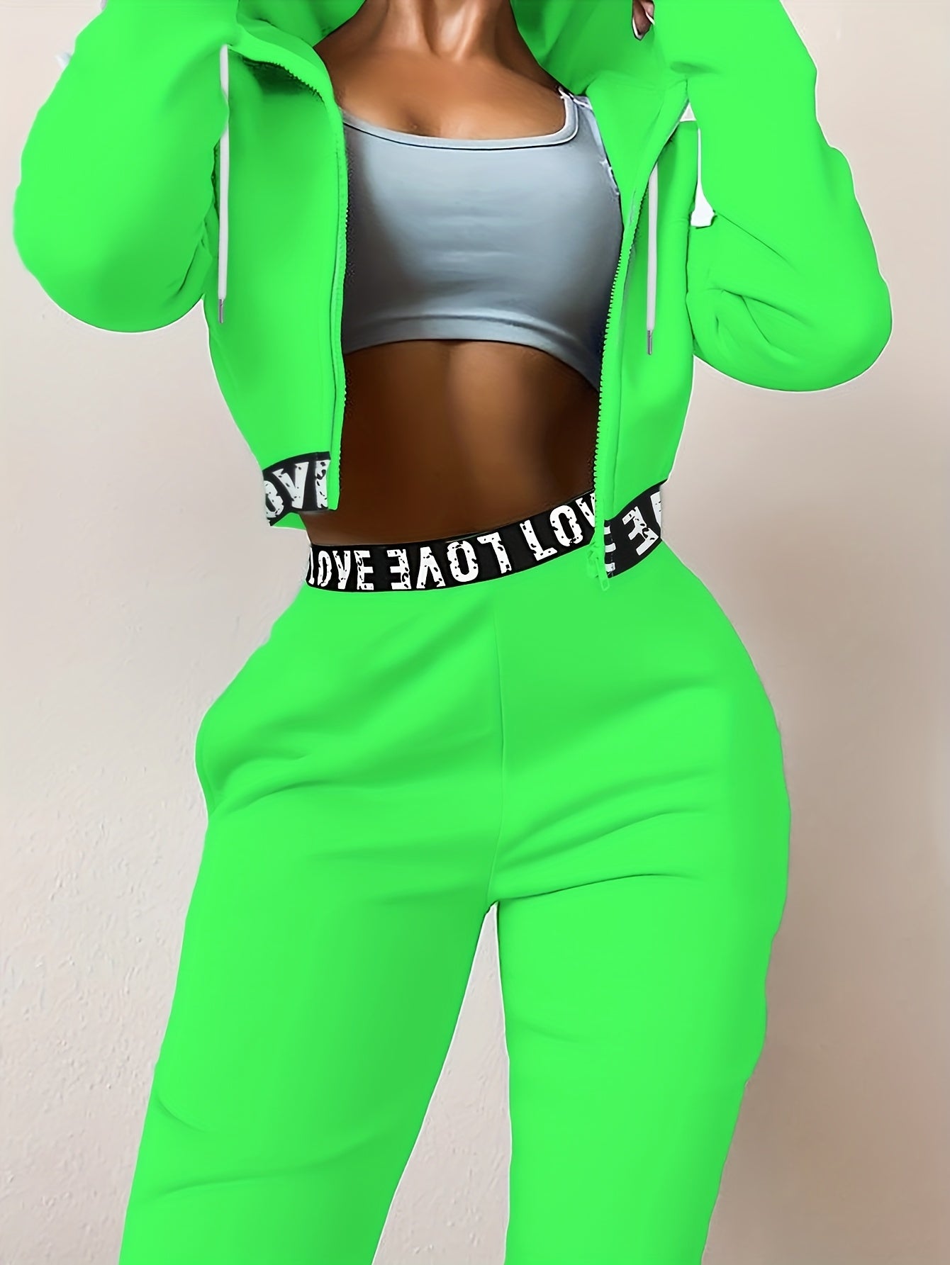 Women's two-piece tracksuit with a hooded jacket and cropped-length joggers featuring a “LOVE” waistband