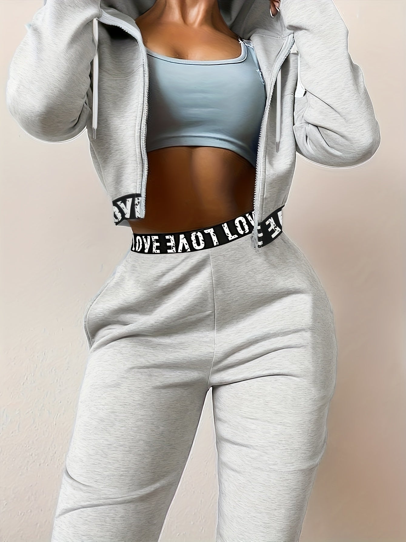Women's two-piece tracksuit with a hooded jacket and cropped-length joggers featuring a “LOVE” waistband