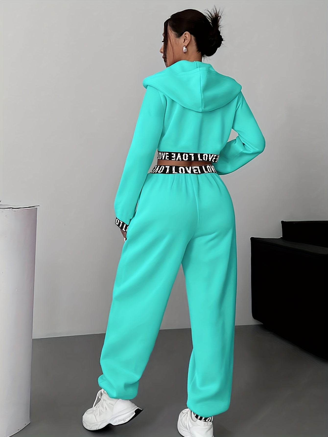 Women's two-piece tracksuit with a hooded jacket and cropped-length joggers featuring a “LOVE” waistband