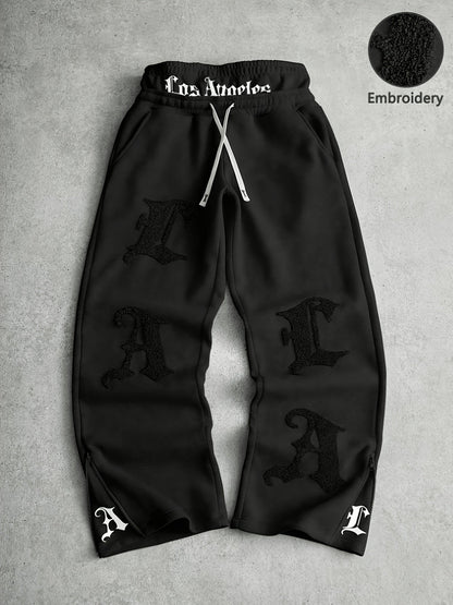 Loose-fit men's joggers with embroidered lettering on the legs, drawstring waistband, black