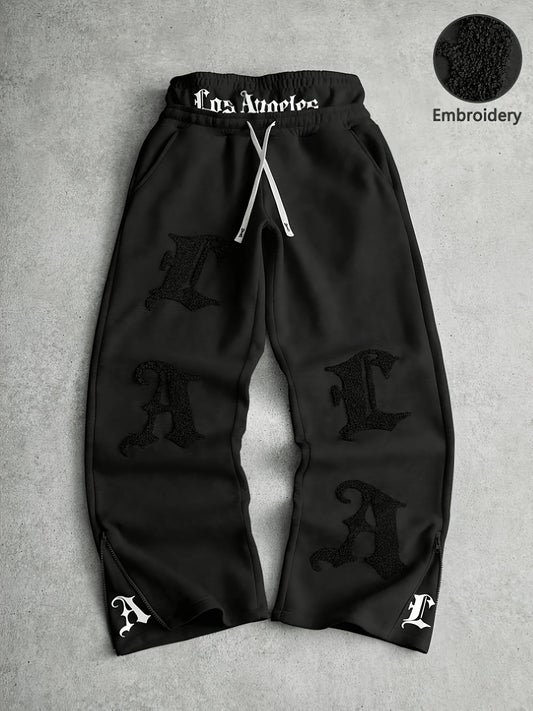 Loose-fit men's joggers with embroidered lettering on the legs, drawstring waistband, black
