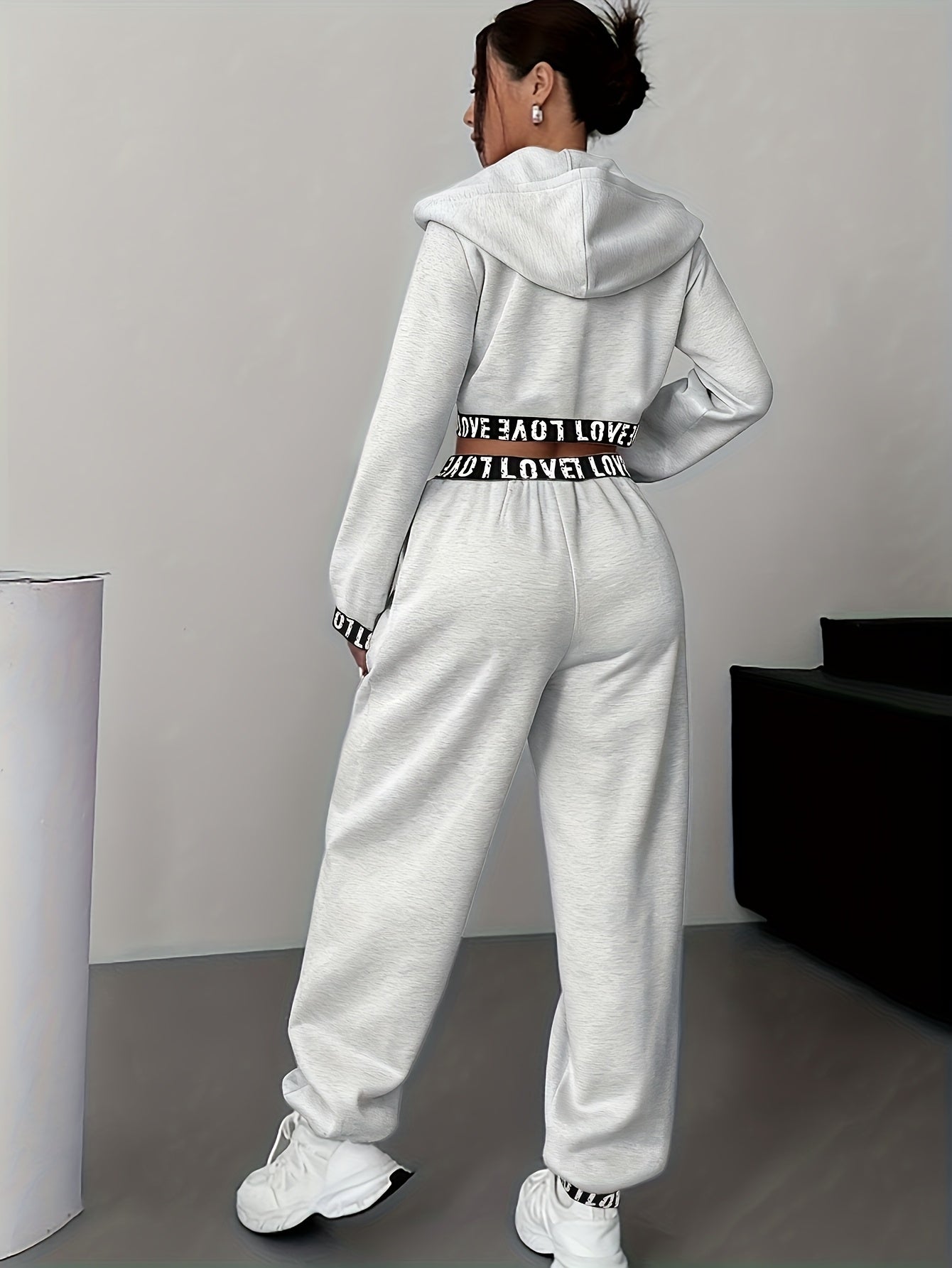 Women's two-piece tracksuit with a hooded jacket and cropped-length joggers featuring a “LOVE” waistband