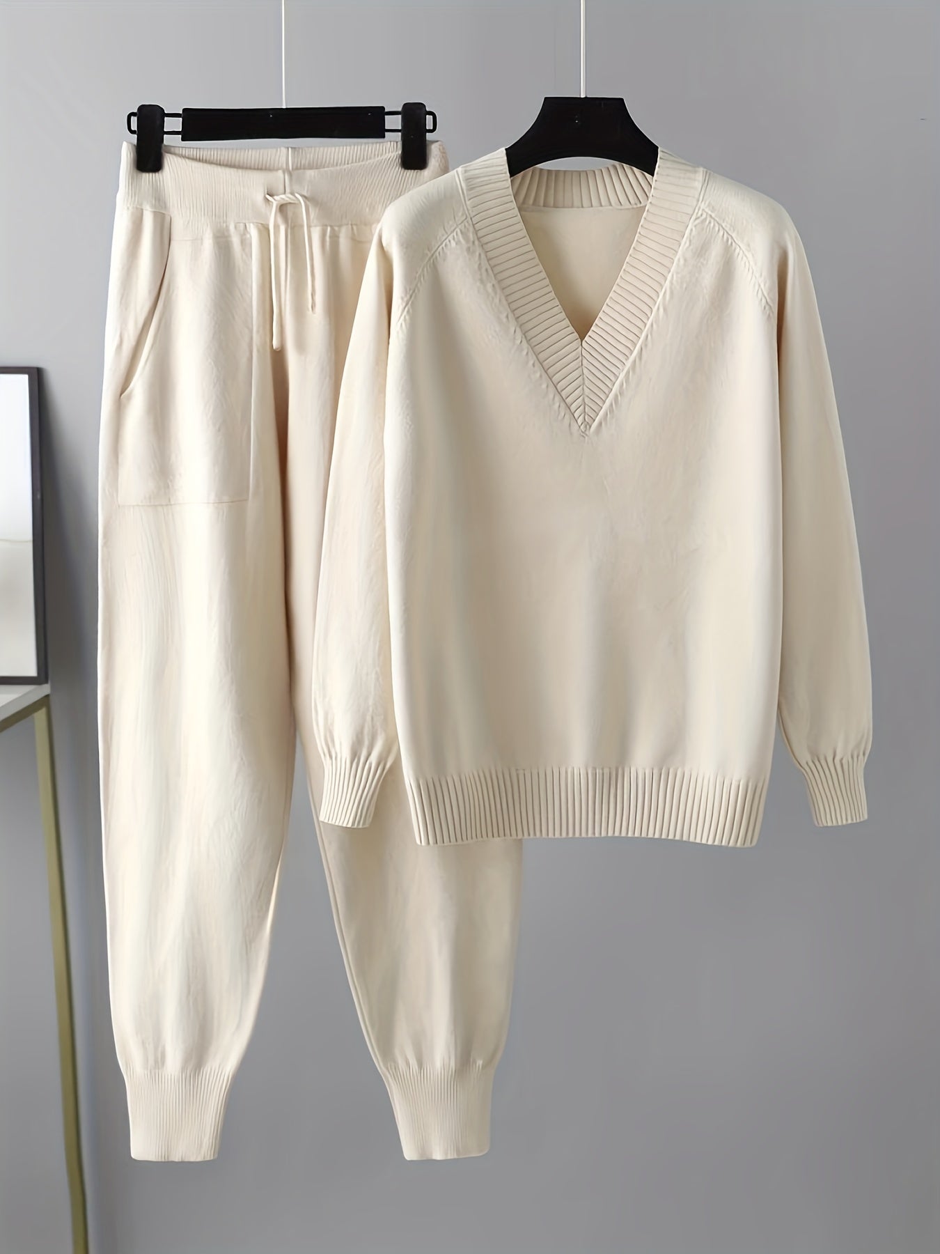 Two-piece women’s knitted set with a V-neck sweater and jogger pants in a beige ribbed-knit design